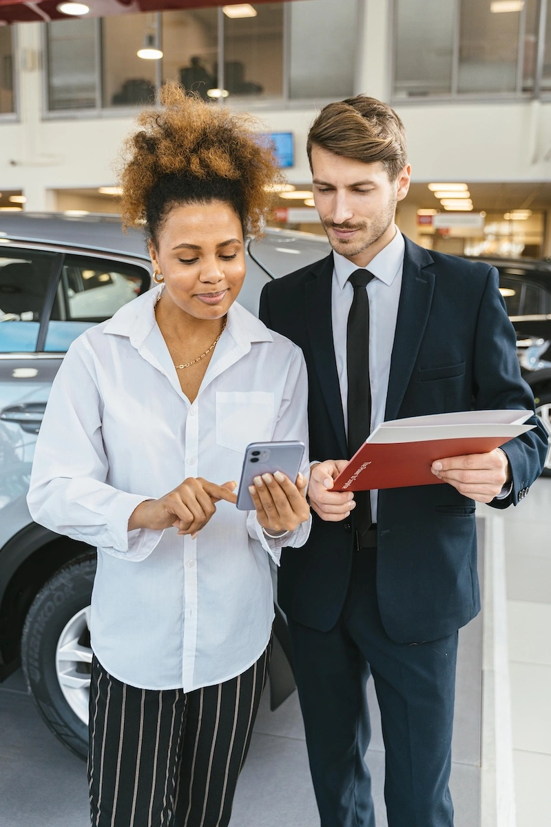 A dealership professional using Trafalgar's mobile technology beside a vehicle